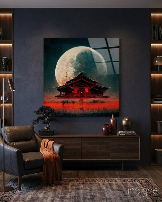 Glass wall art displaying a red Asian temple beneath a large moon against dark teal sky, installed in modern living room.