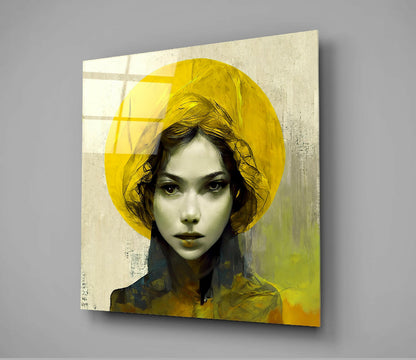 Square glass wall art panel displaying portrait of woman with yellow hat and dark hair against textured beige background with yellow-green tones.