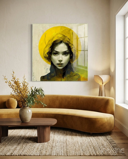 Modern living room with curved tan sofa, wooden table, and glass wall art featuring woman in yellow hat against cream background.