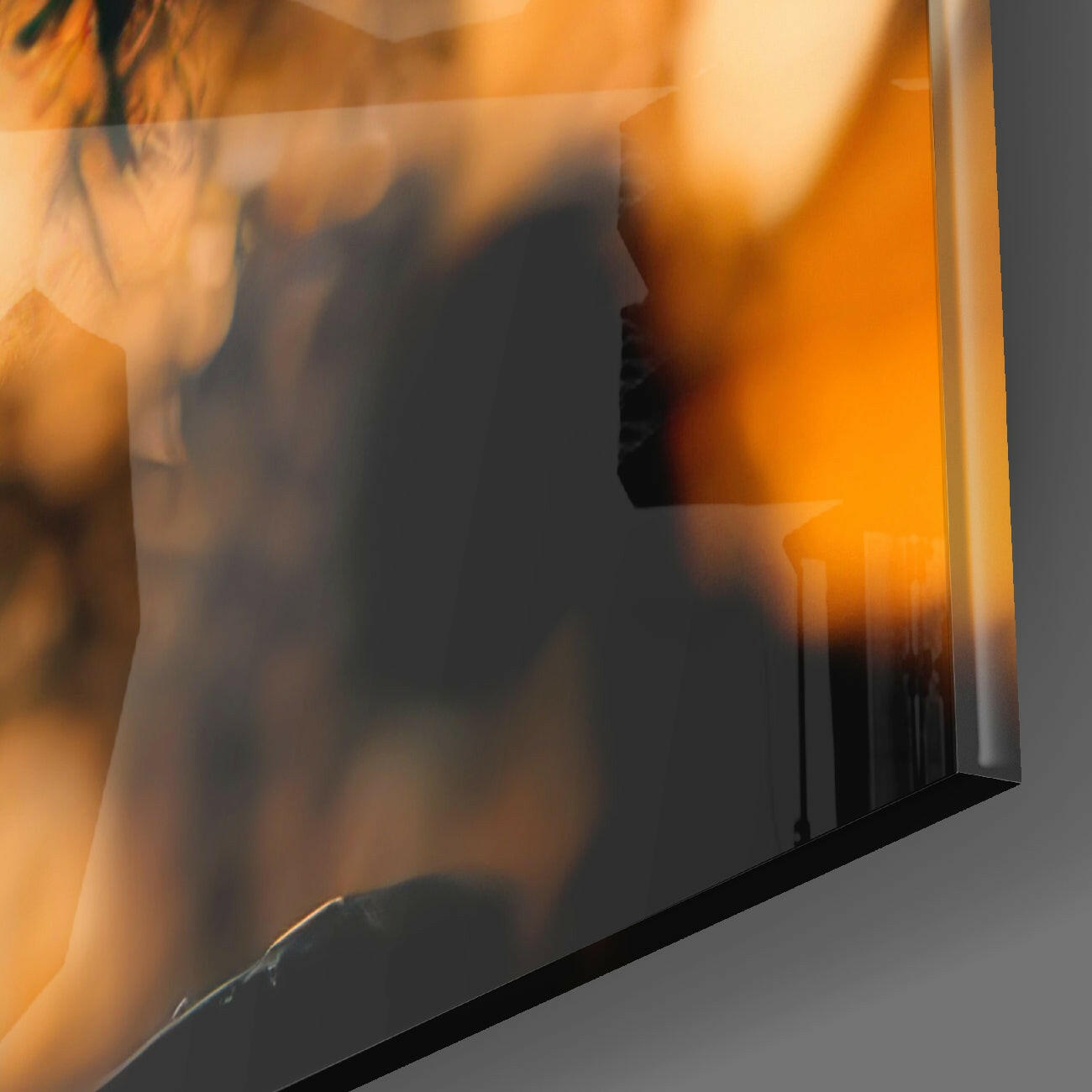 Close-up detail of textured glass surface showing warm orange and amber tones with black frame edge.