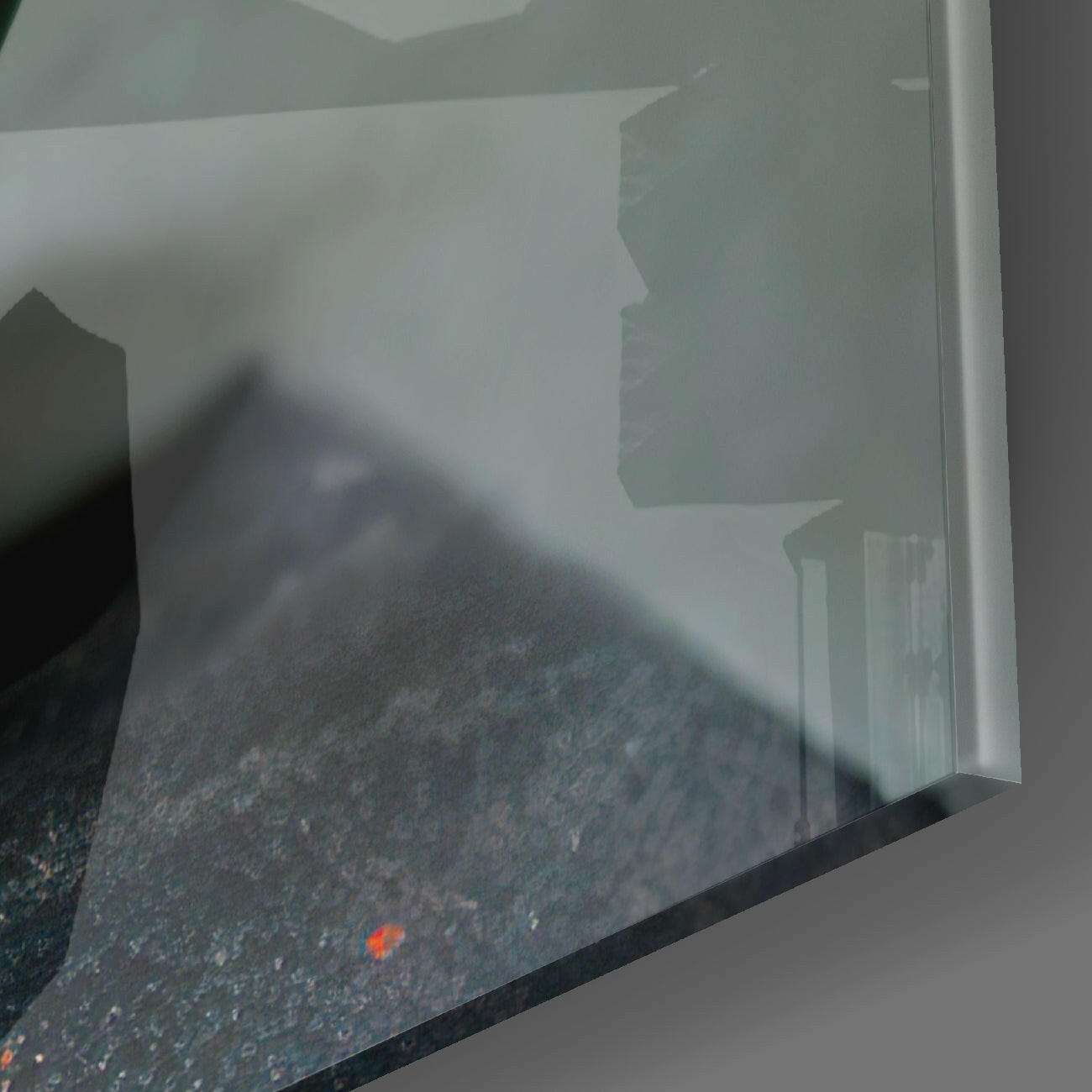 Close-up of Evil Pumpkin glass wall art showing dark textured surface with small orange pumpkin detail against white frame edge.