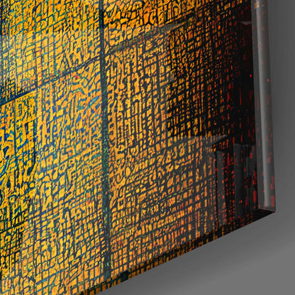 Glass wall art panel displaying yellow and orange pixelated blocks pattern with blue grid lines, photographed at an angle showing depth and shadow.