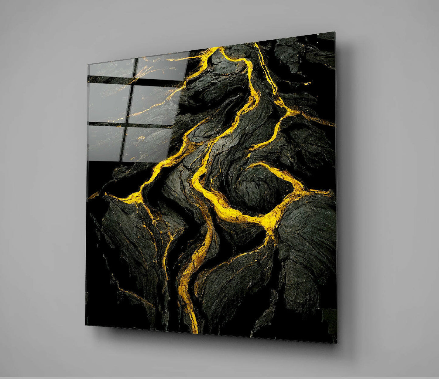 Black lava rock surface with bright yellow and gold veining displayed on angled glass panel with black grid overlay.