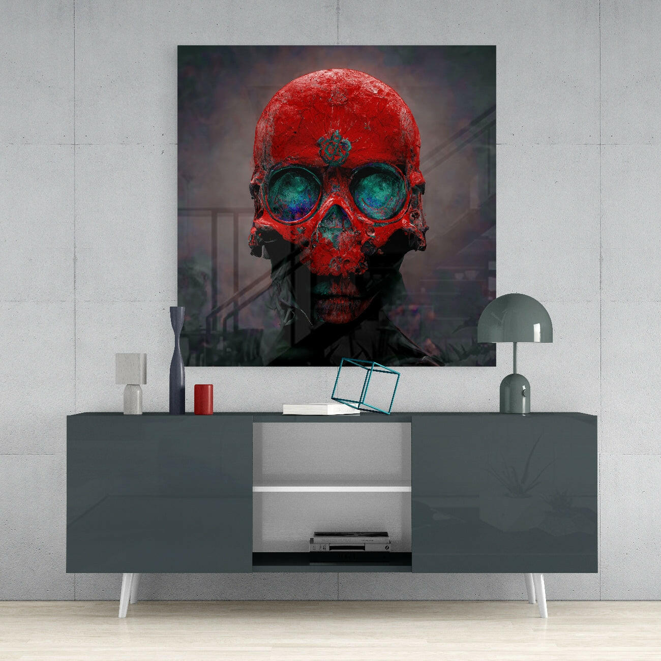 Red skull glass wall art with bright red surface and turquoise eye sockets displayed above modern gray media console.