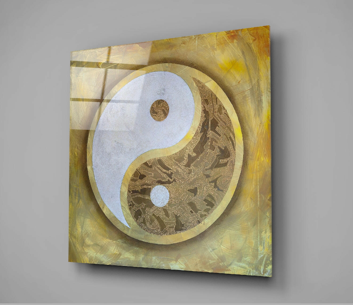 Yin Yang glass wall art mounted on gray wall, displaying light blue and gold patterned halves with ornate detailing against warm yellow-toned background.