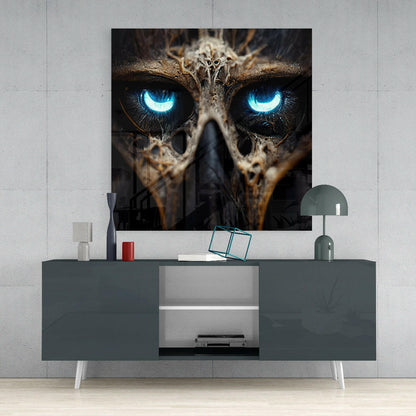 Glass wall art featuring a owl's face with glowing blue eyes displayed above a gray media console in a modern interior setting.