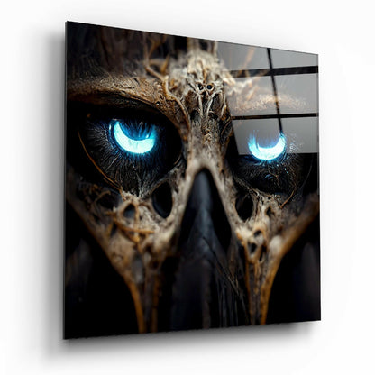 Close-up angled view of glass wall art featuring an owl's face with striking bright blue glowing eyes against dark plumage and textured background.