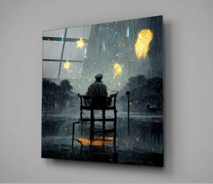 Silhouetted figure seated on chair at window during rainy night with glowing yellow stars on dark glass art panel.