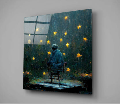 A solitary figure in blue sits on a wooden chair facing a rain-streaked window with glowing yellow stars, displayed as a glass wall panel.
