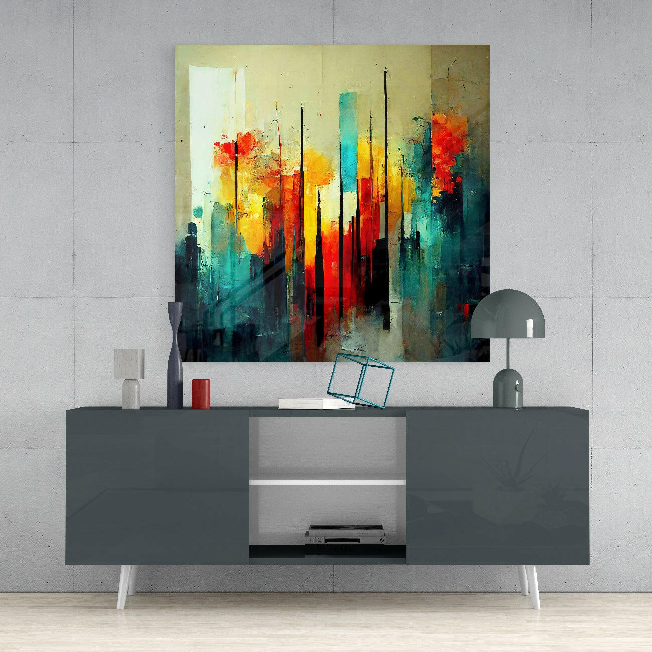 Abstract cityscape glass wall art in vibrant reds, yellows, and teals displayed above a modern gray media console.