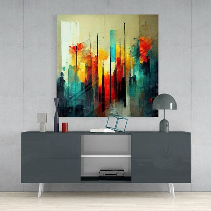 Abstract cityscape glass wall art in vibrant reds, yellows, and teals displayed above a modern gray media console.