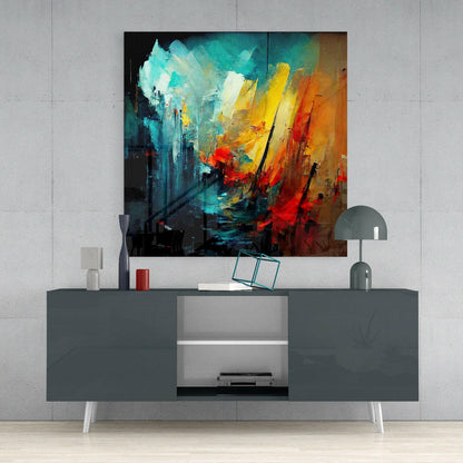 Abstract glass wall art featuring turquoise, yellow, orange, and red brushstrokes displayed above a gray media console in a modern interior setting.