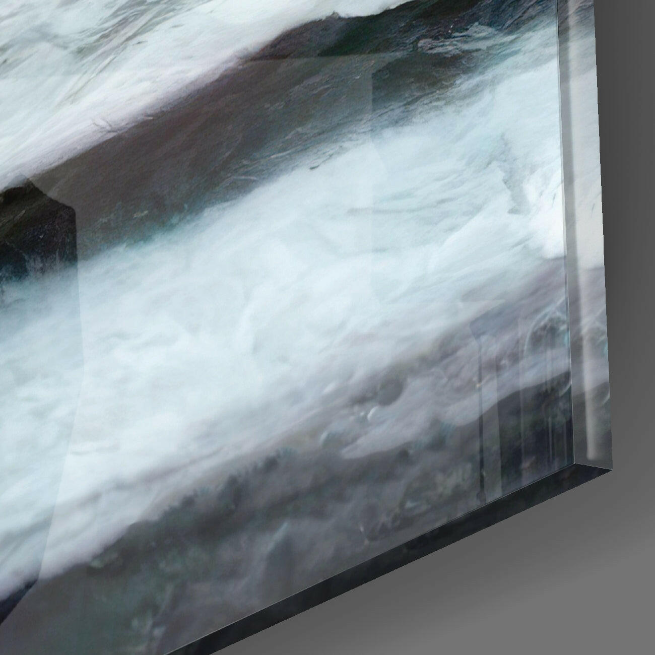 Close-up angled view of Master Glass Wall Art showing turbulent white water and dark rocky terrain printed on translucent glass panel with black frame edge.