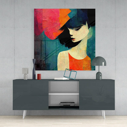 Colorful abstract portrait of woman with red and orange geometric shapes displayed on wall above gray media console with accessories.