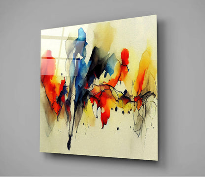 Abstract glass wall art panel displaying vibrant watercolor-style figures in red, blue, yellow, and black on cream background, mounted at angle against gray wall.