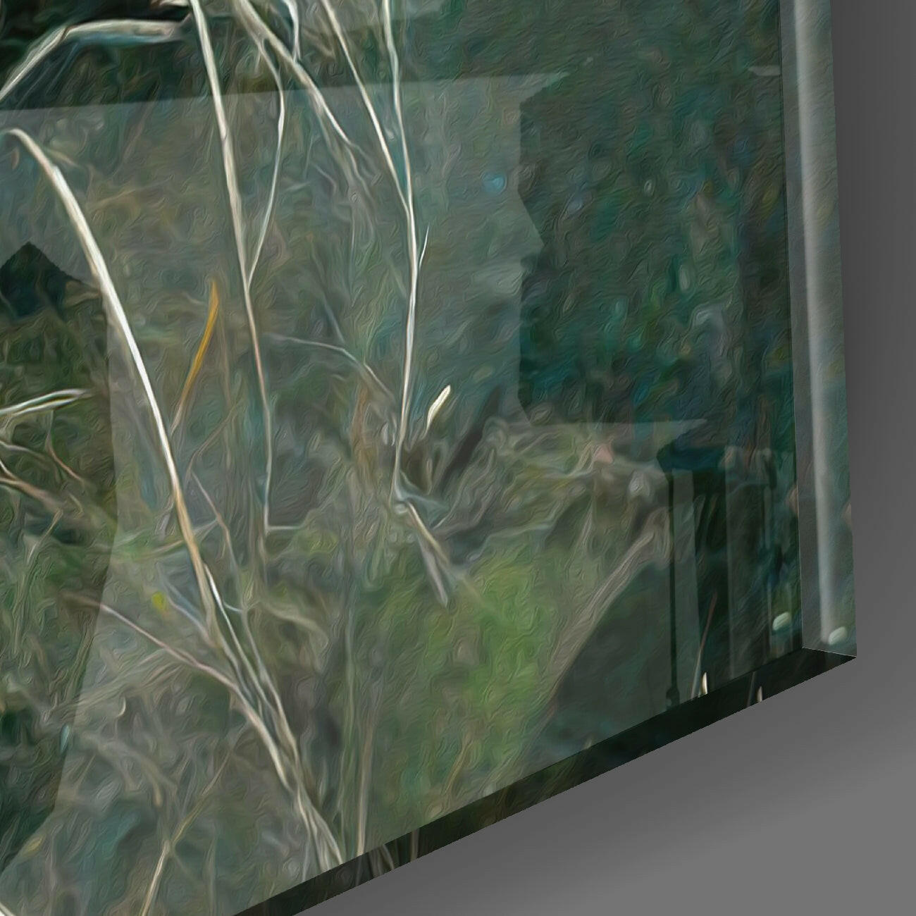 Close-up angled view of textured glass wall art panel showing layered green, teal, and neutral tones with white branch-like patterns and metal frame edge.