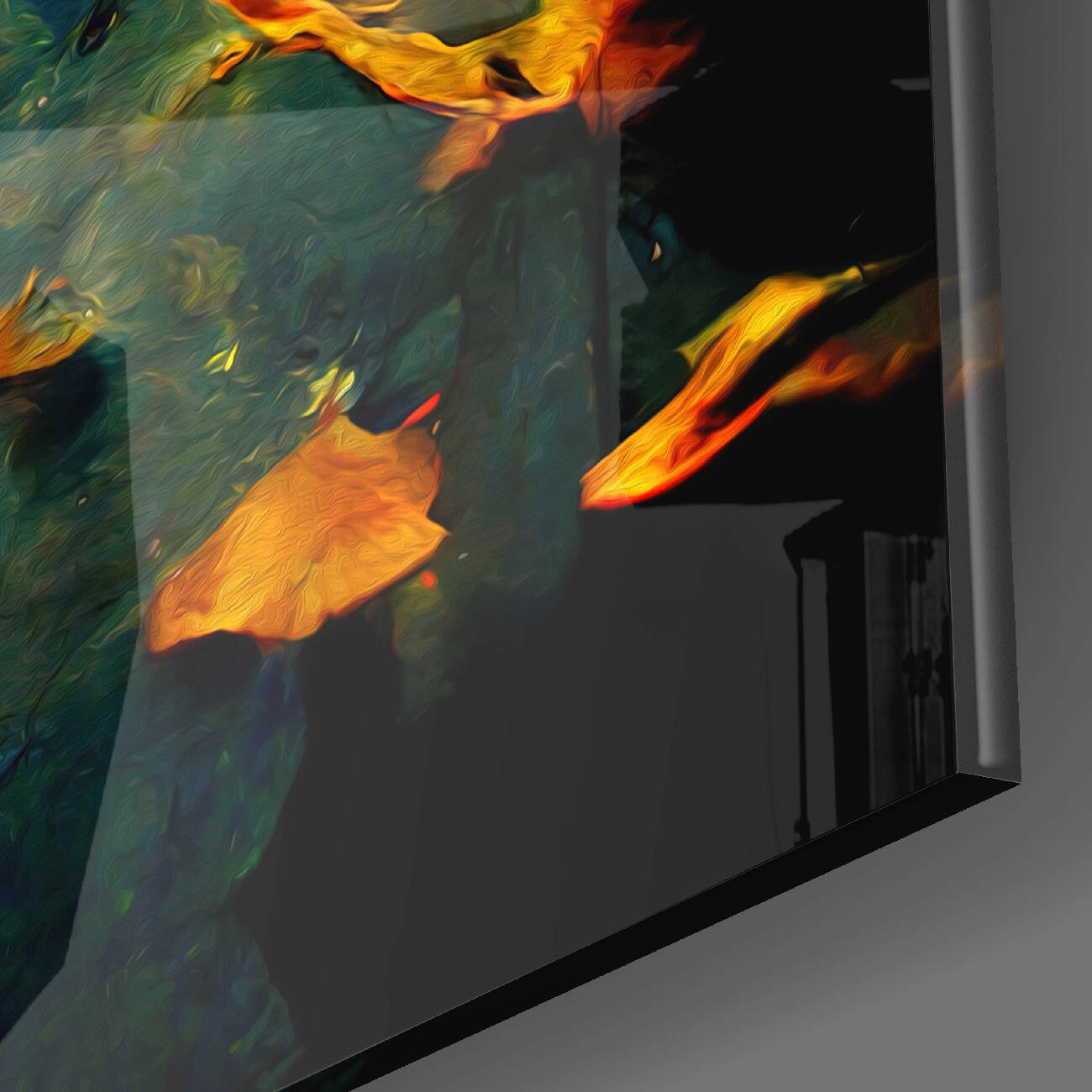 Close-up angled view of glass wall art displaying golden-yellow and orange autumn leaves against deep teal and black background.