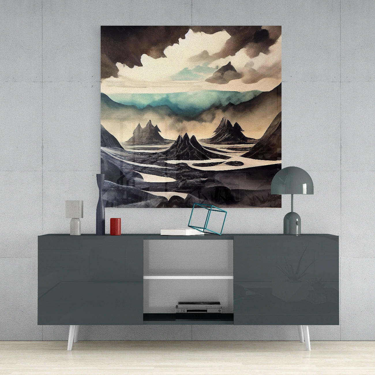 Glass wall art print depicting an Icelandic landscape with dark volcanic peaks, misty valleys, and dramatic cloudy sky in muted earth tones mounted above a gray media console.