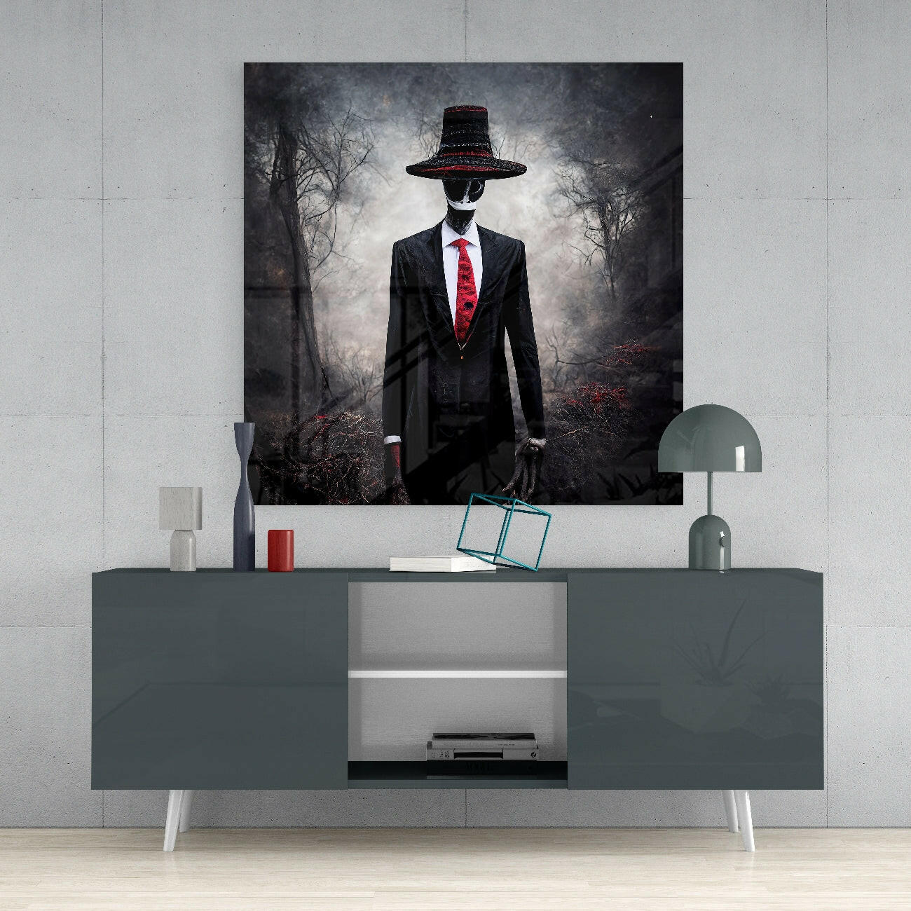 Glass wall art depicting a suited figure in a wide-brimmed hat and red tie standing in a bare forest, displayed above a gray media console.