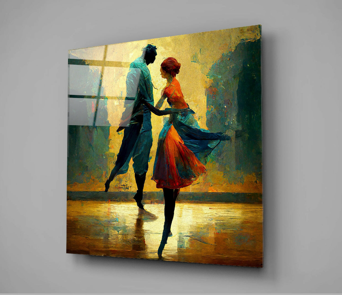Glass wall art panel displaying two silhouetted dancers in vibrant orange and teal against a weathered yellow-green textured background, mounted on gray wall.