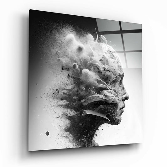Black and white glass wall art showing a man's profile dissolving into scattered particles, displayed at an angle against a window background.