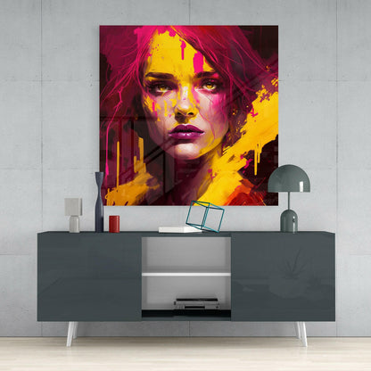 Vibrant portrait glass wall art in magenta and yellow displayed above gray sideboard in modern interior setting.