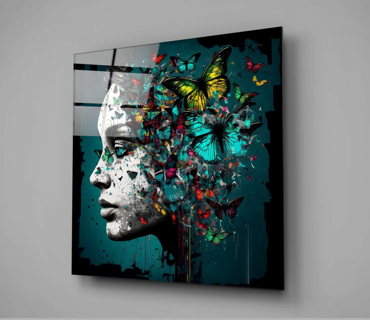 Glass wall art mounted on gray wall showing white sculptured profile with colorful butterflies emerging from head against teal background.