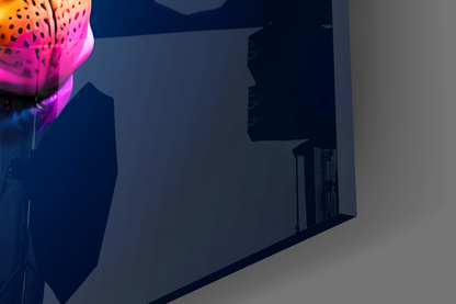 Neon pink and blue glass wall art with spotted pattern displayed on dark interior wall.