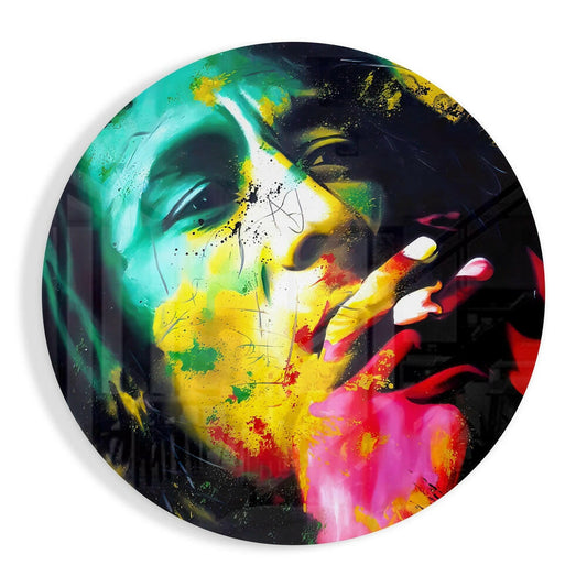 Circular glass wall art featuring a colorful portrait with neon splashes of green, yellow, pink, and red on a dark background.