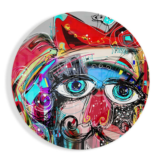 Vibrant circular glass wall art featuring a stylized face with large cyan eyes, multicolored graffiti-style design in red, pink, and turquoise tones.