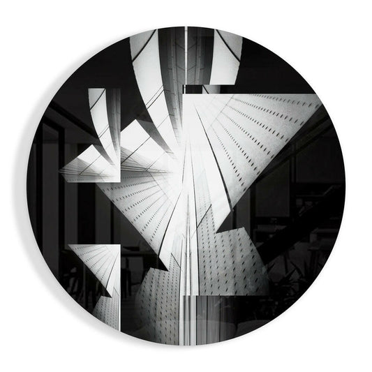 Black and white photograph of tall skyscrapers shot from below, displayed on a circular glass wall art piece.
