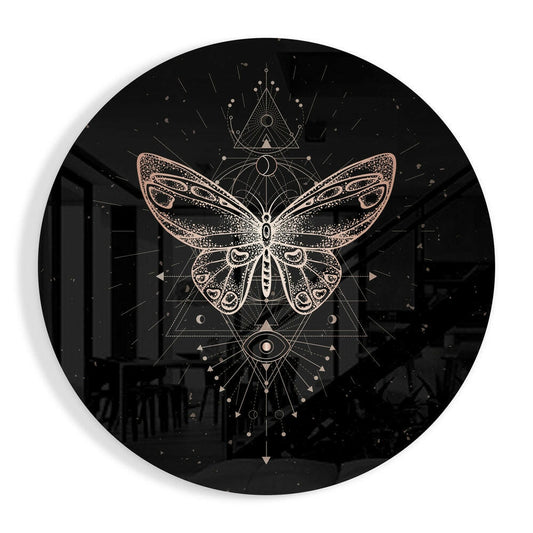 Circular black glass wall art featuring a copper and gold geometric butterfly centered within mystical symbols and radiating lines.