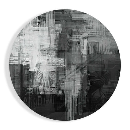 Circular glass wall art with layered black, white, and gray vertical striations creating an abstract textured pattern against white background.