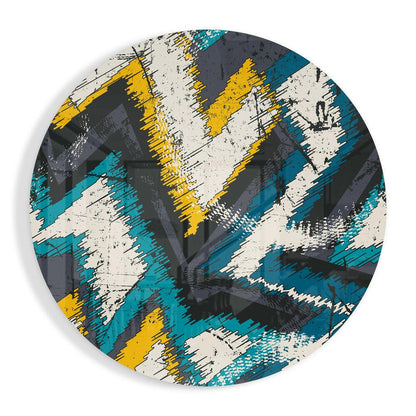 Circular glass wall art with diagonal brushstroke pattern in teal, yellow, cream, and charcoal, viewed from front.