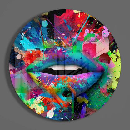 Vibrant multicolored abstract splatter design on circular glass wall art featuring lips with white teeth against gray background.