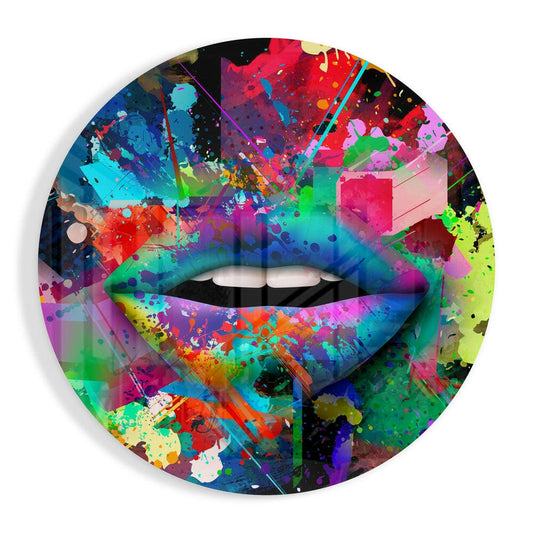 Circular glass wall art displaying a colorful abstract design with vibrant splashes of red, blue, green, yellow, and pink surrounding a central lip motif with white teeth.