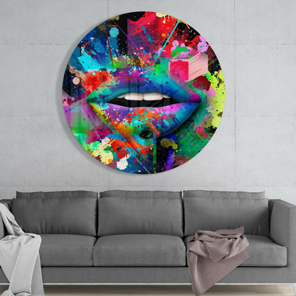 Colorful abstract lip glass wall art with vibrant paint splatter design hanging above gray sofa in modern living room.