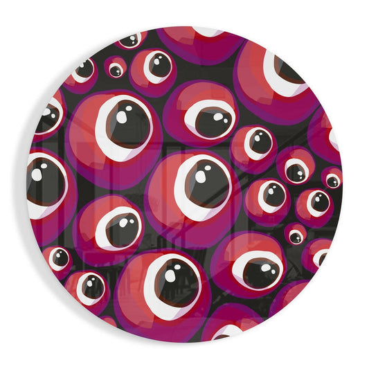 Circular glass wall art featuring overlapping red and purple evil eye beads with black pupils and white highlights on dark background.