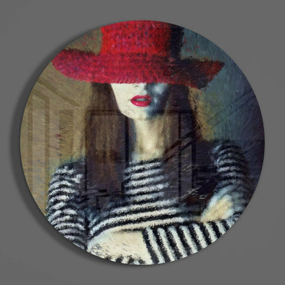 Circular glass art featuring a woman in a red hat with striped gloves against an urban architectural background.