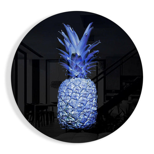 Bright blue glass pineapple sculpture displayed on circular black mirror, illuminated against dark interior room background.