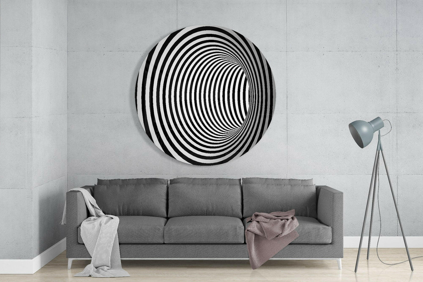 Black and white concentric circle glass wall art displayed above gray sofa in minimalist living room interior.