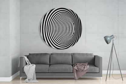 Black and white concentric circle glass wall art displayed above gray sofa in minimalist living room interior.