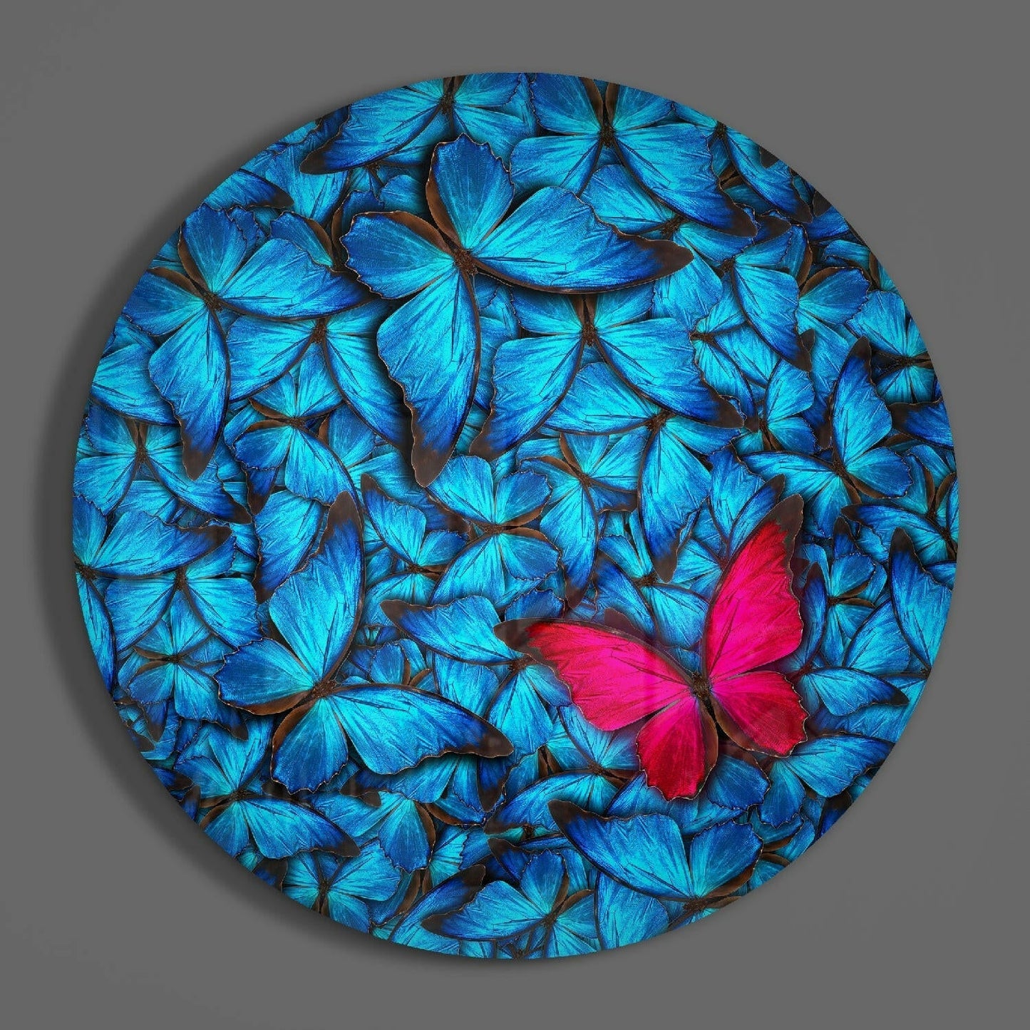 Circular glass wall art displaying bright blue butterflies with one vibrant red butterfly among them, front view against gray background.