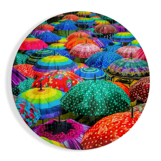 Circular glass wall art displaying a dense overhead view of multicolored polka dot umbrellas in vibrant rainbow hues with various patterns.