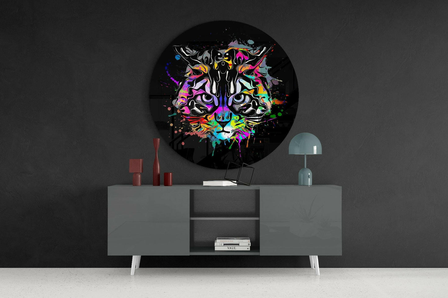 Colorful neon tiger face artwork displayed as round wall art above gray mid-century modern sideboard in dark interior setting.