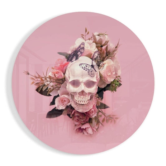 Circular pink glass wall art featuring a pale skull surrounded by pink roses and purple butterflies against a soft pink background.