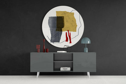 Abstract glass wall art with yellow, gray, and red geometric shapes displayed above a gray sideboard with decorative items.