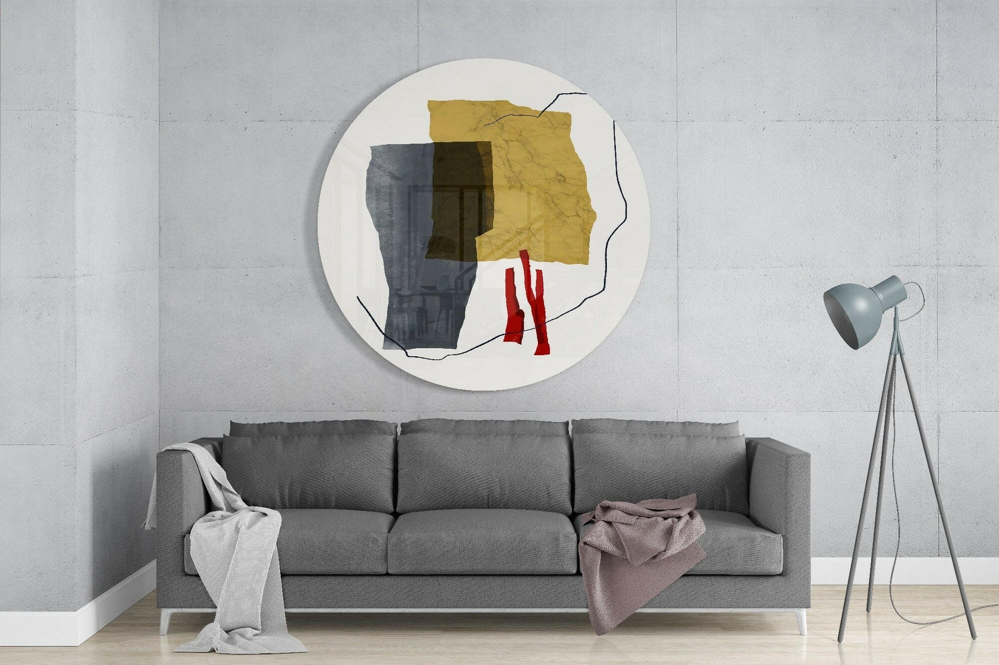 Circular glass wall art with abstract geometric design in yellow, dark blue, olive, and red shapes on white background, mounted above gray sofa.