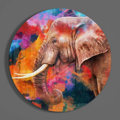 Circular glass wall art featuring a detailed elephant head in profile against a vibrant, multicolored watercolor background of orange, pink, blue, and purple hues.