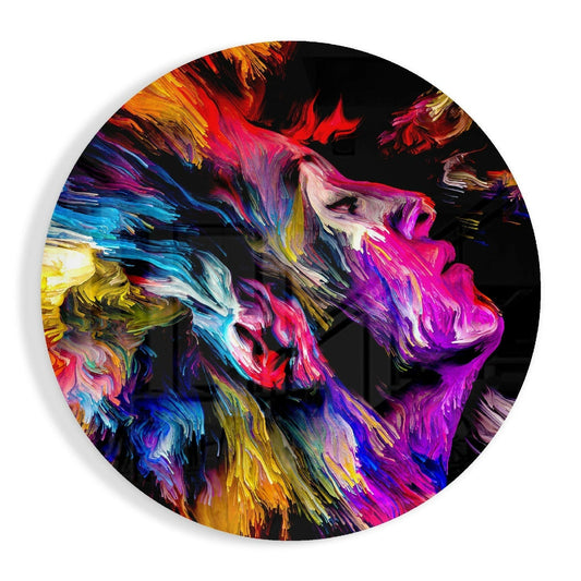 Circular glass wall art featuring a colorful abstract profile of a face with vibrant streaked brushstrokes in magenta, blue, yellow, and orange against a black background.